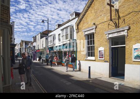 An einem sonnigen Sonntagmorgen laufen die Shopper an der Harbour Church in der Harbour Street, Whitstable vorbei Stockfoto