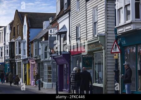 An einem sonnigen Sonntagmorgen im April bummeln die Käufer durch die unabhängigen Geschäfte in der Harbour Street, Whitstable, Großbritannien Stockfoto