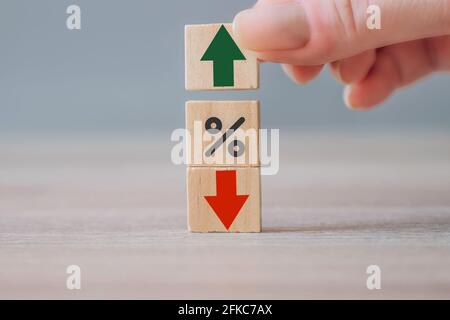 Geschäftswachstum, Erfolg, process Konzept. Prozentsymbol, roter Pfeil nach unten und Hand Auswahl Holzwürfel mit grünem Pfeil nach oben. Zinssätze, Stockfoto