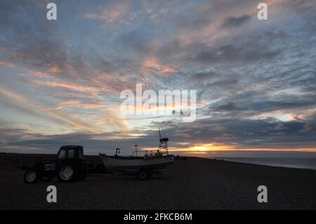 Krabbenboot und Traktor bei Sonnenuntergang am Cley-next-the-Sea Beach im Norden von Norfolk, England, Großbritannien Stockfoto