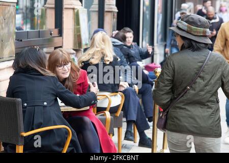 London, Großbritannien. 30. April 2021. Trotz kühleren Wetters und starkem Verkehrsaufkommen sitzen die Menschen vor den Cafés auf Piccadilly, da das Essen im Innenbereich erst am 17. Mai erlaubt ist. Quelle: Anna Watson/Alamy Live News Stockfoto