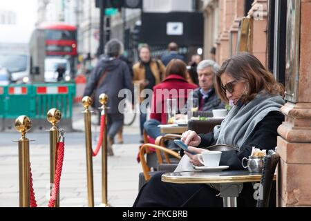 London, Großbritannien. 30. April 2021. Trotz kühleren Wetters und starkem Verkehrsaufkommen sitzen die Menschen vor den Cafés auf Piccadilly, da das Essen im Innenbereich erst am 17. Mai erlaubt ist. Quelle: Anna Watson/Alamy Live News Stockfoto