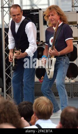 STATUS QUO'S RICK PARFITT UND FRANCIS ROSSI AUF DER BÜHNE AN BORD DER HMS ARK ROYAL IN PORTSMOUTH, WO DIE BAND FÜR DIE CREW AUFTRAT, UM IHR NEUES ALBUM ZU VERÖFFENTLICHEN. PIC MIKE WALKER, 2002 Stockfoto