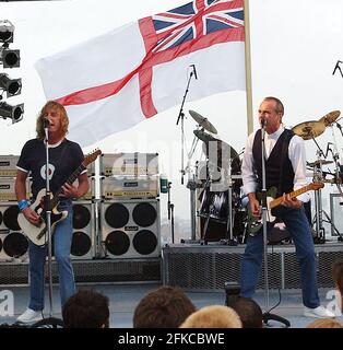 STATUS QUO'S RICK PARFITT UND FRANCIS ROSSI AUF DER BÜHNE AN BORD DER HMS ARK ROYAL IN PORTSMOUTH, WO DIE BAND FÜR DIE CREW AUFTRAT, UM IHR NEUES ALBUM ZU VERÖFFENTLICHEN. PIC MIKE WALKER, 2002 Stockfoto