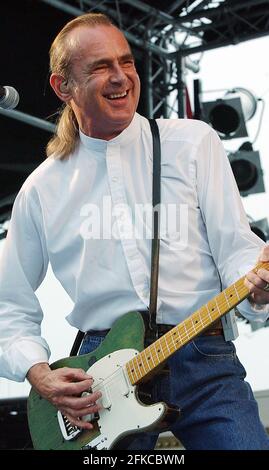 STATUS QUO'S FRANCIS ROSSI AUF DER BÜHNE AN BORD DER HMS ARK ROYAL IN PORTSMOUTH, WO DIE BAND FÜR DIE CREW AUFTRAT, UM IHR NEUES ALBUM ZU VERÖFFENTLICHEN. PIC MIKE WALKER, 2002 Stockfoto