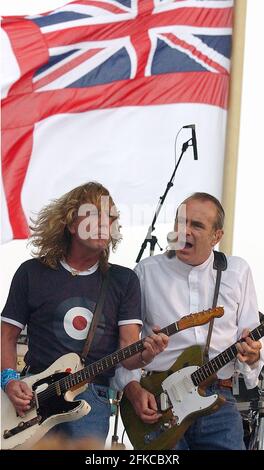 STATUS QUO'S RICK PARFITT UND FRANCIS ROSSI AUF DER BÜHNE AN BORD DER HMS ARK ROYAL IN PORTSMOUTH, WO DIE BAND FÜR DIE CREW AUFTRAT, UM IHR NEUES ALBUM ZU VERÖFFENTLICHEN. PIC MIKE WALKER, 2002 Stockfoto