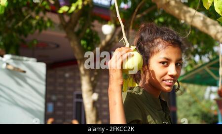 30. April 2021, Jaipur, Rajasthan, Indien. Nettes Mädchen mit Bael oder Bilv Obst. Asiatische Mädchen hält Bilv Frucht in der Hand. Stockfoto