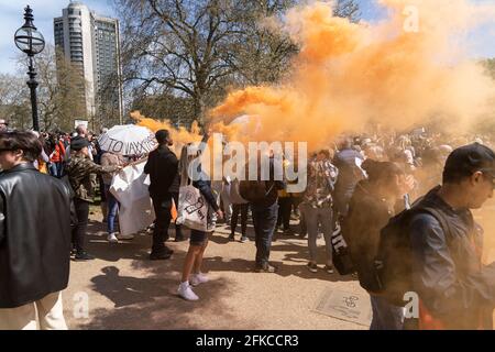 Rauchbomben werden losgelassen, während sich Demonstranten im Hyde Park, London, Großbritannien, versammeln. 24.01.21 Stockfoto