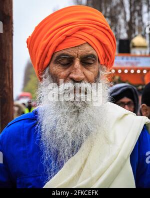 Porträt Sikh-Mann in orangefarbenem Turban (dastar) und Bart in Vaisakhi, Southall, London Stockfoto