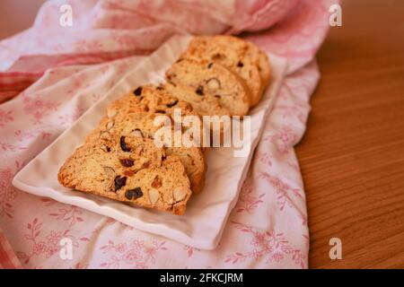 Frisch gekochte Biscotti-Kekse auf einem floralen Appron. Perfekt für die Nachmittagsferien Stockfoto