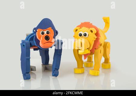 Affe und Spielzeuglöwe, auf weißem Hintergrund, Nahaufnahme Stockfoto