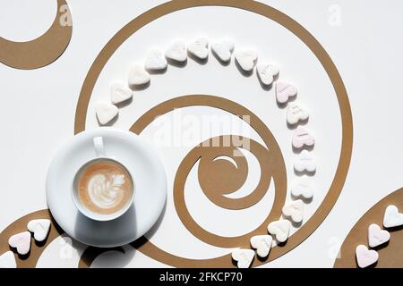 Kaffeetasse, Fibonacci Sequence Kreise aus braunem Papier und Zuckerherzen. Latte Art mit floralem Design, leckerer Perfektion. Golden Ratio-Konzept Stockfoto