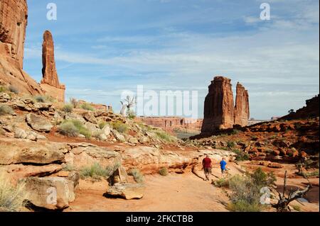 Mann und Junge gehen auf dem Park Avenue Trail, Arches National Park, Utah, USA. Stockfoto