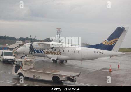 Blue Island Flugzeug Jersey auf dem Boden auf dem Flughafen, um Kurzurlauber an Bord Propeller Flugzeug Flug zeitlich nasse Asphalt bewölkter Himmel Stockfoto