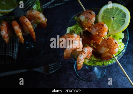 Köstliche frisch gekochte Shrimp-Cocktailvorspeise, serviert in einem tropischen Touristenrestaurant in einem Glas mit Garnelen-Dekoration mit Dill-limo-Spritze Stockfoto