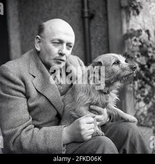 1950er Jahre, ein Porträt von J Allan Cash über Brian Vesey-Fitzgerald mit Hund, einem Naturforscher und Autor von Büchern über Natur, Landleben, Vögel und Hunde. Auch Redakteur des Fachmagazins. Er war ein Nachkomme der Vesty-Fitzgeralds, einer berühmten angoirischen Familie, deren Mitglieder Abgeordnete sowohl in der britischen als auch in der irischen Regierung wurden. Geboren 1905 in Wrexham, Denbighshire, Wales, als Brian Percy Seymour Vesey-Fitzgerald, wird er hier in traditonaler Landkleidung einer Tweed-Jacke und Krawatte gesehen. Er war auch eine Autorität in der Geschichte der Zigeuner auf den Britischen Inseln mit mehreren Büchern zu diesem Thema. Stockfoto