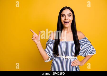 Foto von beeindruckt süße Frau gekleidet Off-Schultern Kleid zeigt ein Finger leeren Raum isoliert gelben Hintergrund Stockfoto