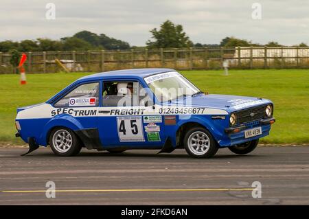 Richard Burns Memorial Rally bei RAF Marham, Norfolk, Großbritannien, mit einem klassischen Ford Escort-Rallyewagen, der mit Geschwindigkeit fährt. Fahrer John Stevens Stockfoto