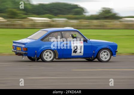 Richard Burns Memorial Rally bei RAF Marham, Norfolk, Großbritannien, mit einem klassischen Ford Escort-Rallyewagen, der mit Geschwindigkeit fährt. Fahrer Martin Hodgson Stockfoto