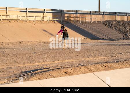 Yuma, Arizona, USA. April 2021. Ein Asylbewerber aus Nicaragua hebt seine Tochter nach der Überfahrt in die Vereinigten Staaten auf seine Schultern. Quelle: Cheney Orr/ZUMA Wire/Alamy Live News Stockfoto