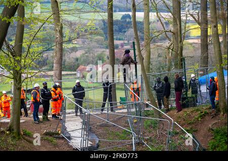 Aylesbury Valle, Buckinghamshire, Großbritannien. April 2021. Ein Protestler steht auf einem Zaun, um eine bessere Sicht zu erhalten. HS2 wurden heute im alten Wald von Jones Hill Wood wieder Buchen gefällt, obwohl es die Vogelnistsaison ist und seltene Barbastellefledermäuse bekannt sind, die in den Wäldern brüten. Der Wald soll den lokalen Autor Roald Dahl dazu inspiriert haben, den beliebten Kinderroman, den fantastischen Mr. Fox, zu schreiben. Die High Speed Rail 2 von London nach Birmingham schnitzt eine riesige Narbe über die Chilterns. Quelle: Maureen McLean/Alamy Live News Stockfoto