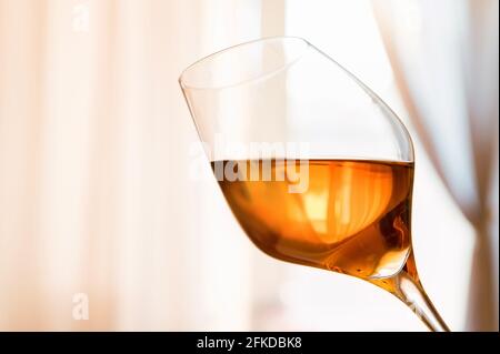 Nahaufnahme eines weißen Porto-Glases mit sanftem Licht im Hintergrund. Selektiver Fokus Stockfoto