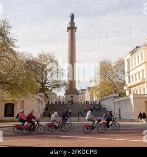 London, Greater London, England - 24 2021. Apr: Radfahrer auf der Mall vor der Statue des Duke of York am Waterloo Place. Stockfoto