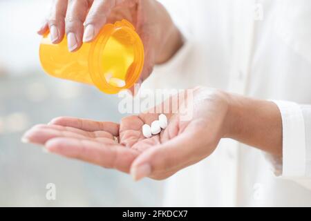 Pillen in die Hand gießen Stockfoto