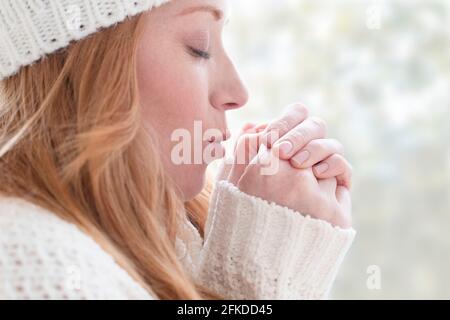 Frau, die ihre Hände wärmend Stockfoto