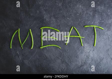 Wort Fleisch in frischen Pods of Green Beans geschrieben Auf dunklem Beton-Hintergrund Stockfoto