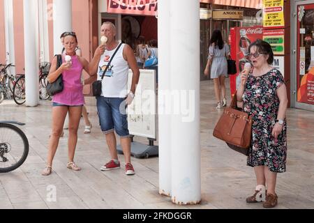 Bild von drei Personen, Ungarn, einer alten Frau und einem Paar, die alle Eis essen im Stadtzentrum von Szeged, ungarn. Stockfoto