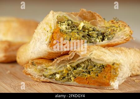Frisch gebackenes Spinat-Dreieck-Gebäck mit dänischem Feta und geröstetem Kürbis. Stockfoto