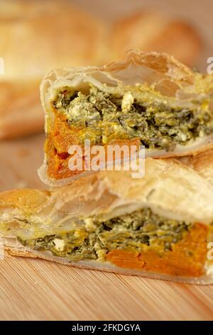 Frisch gebackenes Spinat-Dreieck-Gebäck mit dänischem Feta und geröstetem Kürbis. Stockfoto