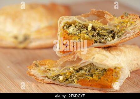 Frisch gebackenes Spinat-Dreieck-Gebäck mit dänischem Feta und geröstetem Kürbis. Stockfoto