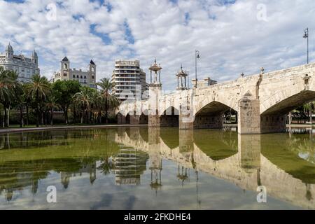 Spiegelungen einer alten Steinbrücke über das alte Flussbett. Puente del Mar, Fluss Turia, Valencia, Spanien Stockfoto