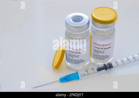 Calgary, Alberta, Kanada. 29. April 2021. Ein paar Johnson & Johnson-Dosen von Covid-19-Impfstoffen auf Fläschchen und einer Injektionsspritze. Stockfoto