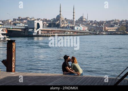 Istanbul, Türkei. April 2021. Ein Touristenpaar sah am Goldenen Horn küssen. Die türkische Regierung hat eine 17-tägige Ausgangssperre angekündigt, um die wachsende Zahl von Covid-19-Fällen zu bekämpfen. Am ersten Tag der Ausgangssperre waren die Straßen fast leer. Die Aussicht auf Istanbul haben vor allem die Touristen genossen. Kredit: SOPA Images Limited/Alamy Live Nachrichten Stockfoto