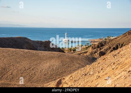 Eilat, Israel - 31 2021. März: Berge in der Wüste vor dem Hintergrund des Roten Meeres mit dem Eilat Underwater Observatory Marine Park. Shlomo Mountain, Eilat Israel, Mars like Landscape Stockfoto