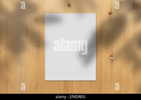 Weißes Papier Mockup auf Holzwand mit realistischen Schatten überlagert Blätter auf beigem Hintergrund, Banner für Promotion-Marketing, Hintergrund für Stockfoto