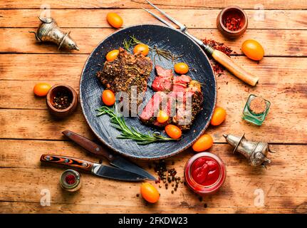 Rindersteak in Scheiben, geröstet mit Kumquat, Rosmarin und Gewürzen. Kalbsentrecote Eine Platte Stockfoto