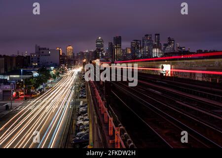 Eine U-Bahn, die eine erhöhte Brücke mit der Skyline von passiert New York im Rückstand Stockfoto