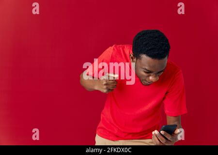 Verärgerte Mann mit Telefon in den Händen Emotionen isoliert Hintergrund-Technologie Stockfoto