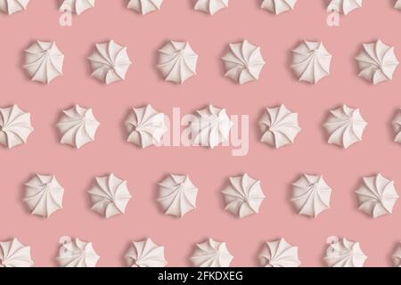 Nahtloses Muster mit Meringue Cookies auf einem rosa Hintergrund als Kreative Textur Stockfoto