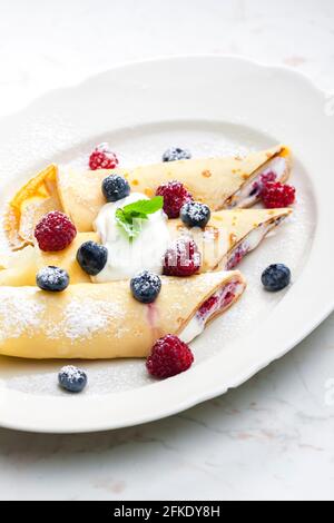 Pankaces gefüllt mit Heidelbeeren, Himbeeren und Rahm Stockfoto