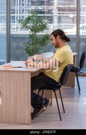 Männlicher Schüler im Klassenzimmer sitzen Stockfoto