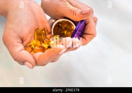 Frau mit einem Glas Omega-3-Vitaminen in sich Nahaufnahme der Hände Stockfoto