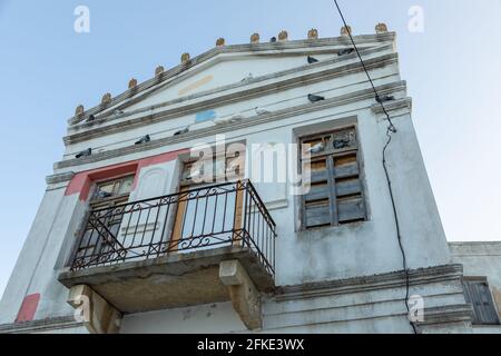 Blick auf die Fassade eines zerstörten Gebäudes in Lefkes. Windows Boarding Up, Lefkes, Paros Island, Griechenland. Stockfoto