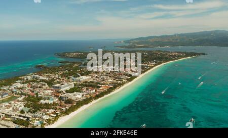 Tropische Lagune mit türkisblauem Wasser und weißem Sand Beach Boracay, Philippinen. White Beach mit Touristen und Hotels. Tropischen Strand mit Segelboot. Stockfoto