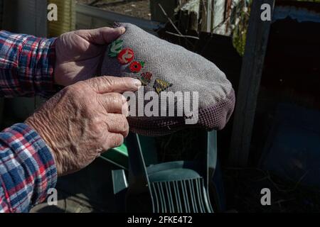 In der britischen Populärkultur wird die flache Kappe typischerweise mit älteren Männern der Arbeiterklasse assoziiert. Taubenfantasie mit Taubenstickerei auf seiner Kappe. Stockfoto