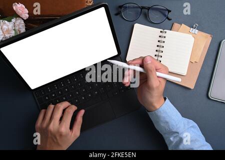 Oben Ansicht des Geschäftsmannes, der den Stift hält und auf den Bildschirm des Computertabletts am Schreibtisch zeigt. Stockfoto